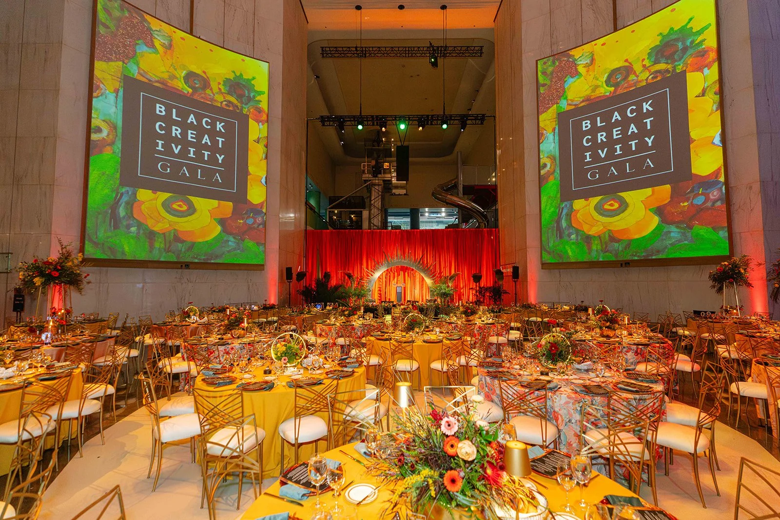 Wide view of the Black Creativity Gala ballroom with branded projections
