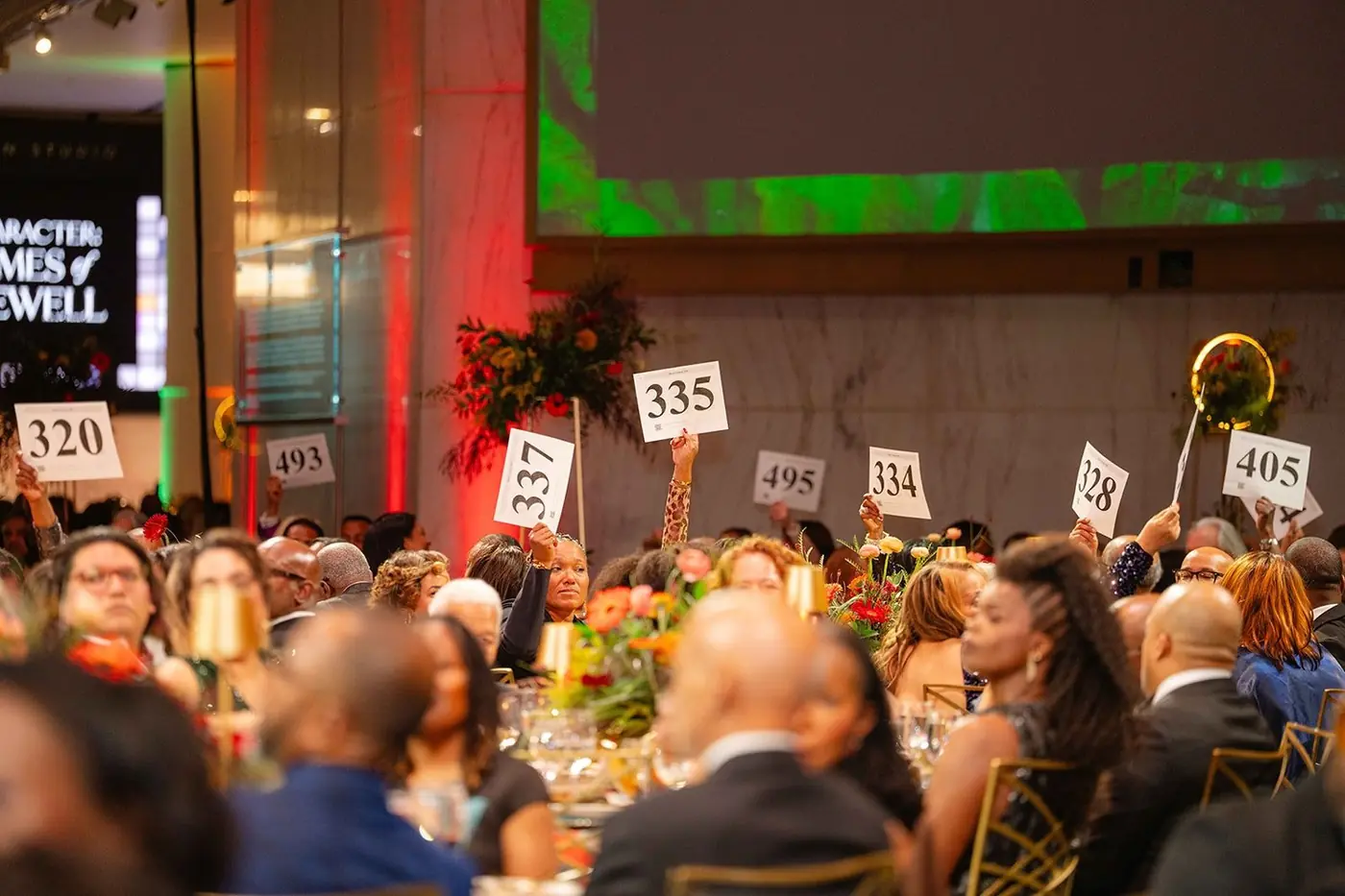 Guests raising auction paddles at the Black Creativity Gala
