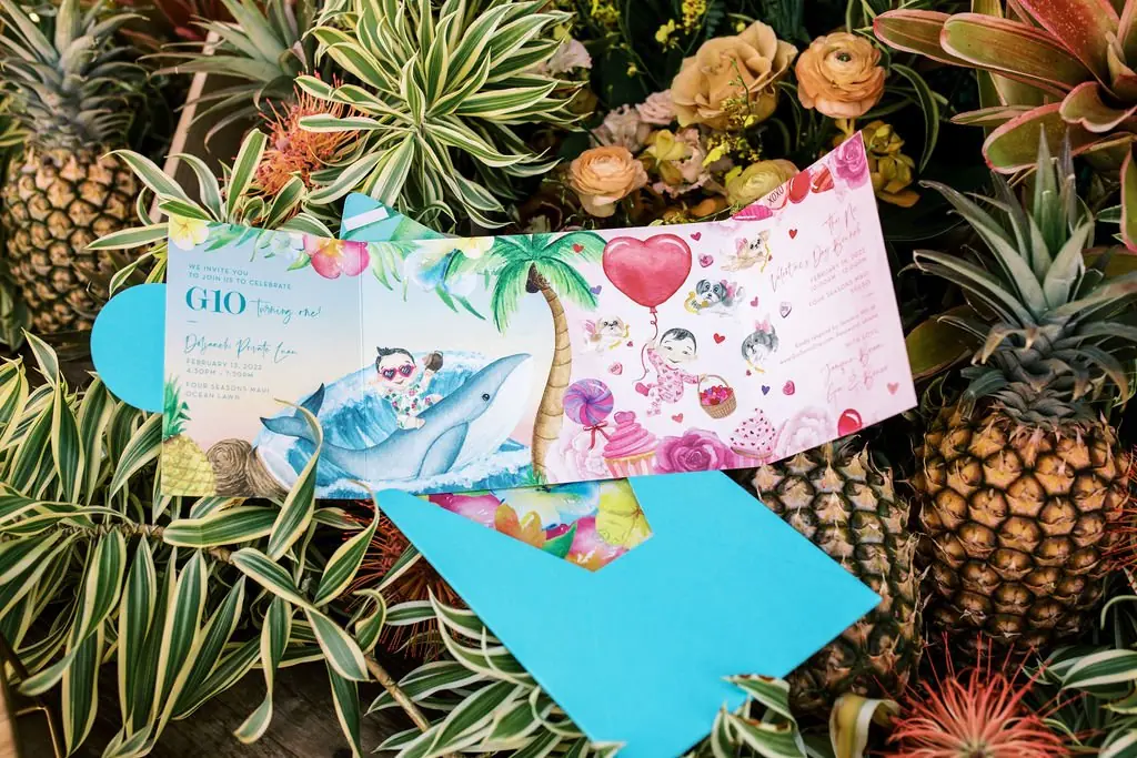 Gio first birthday invitation flat lay with pineapples and tropical florals
