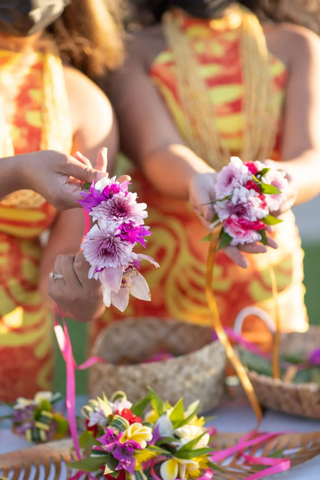 Guests holding floral wrist pieces with yellow leis