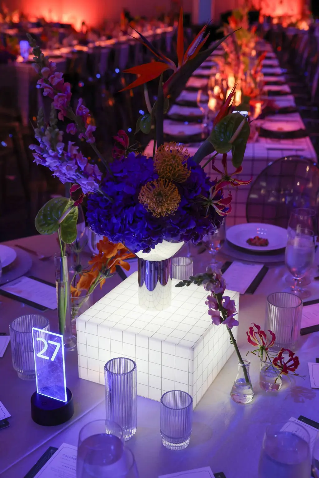 Science-themed floral centerpiece with lab glassware at table 27