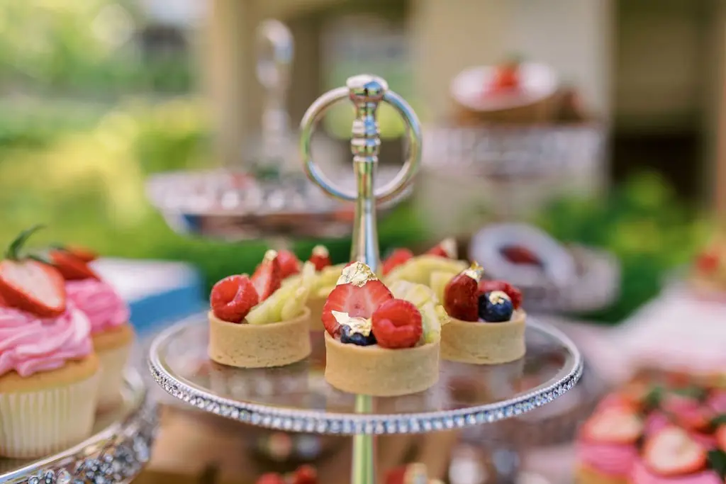 Fruit tarts with edible gold leaf on a crystal-rimmed stand