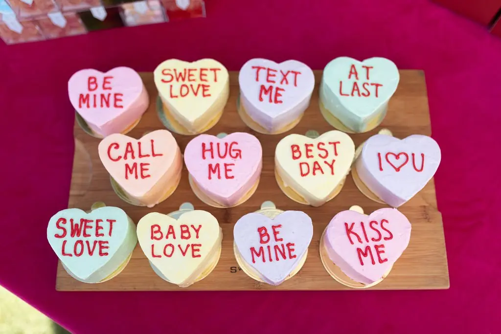 Conversation-heart mini cakes on a wooden board