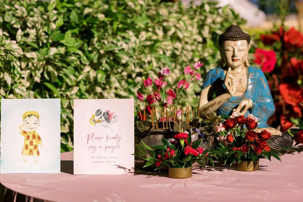 Prayer table with Buddha, incense, and illustrated cards for Gio