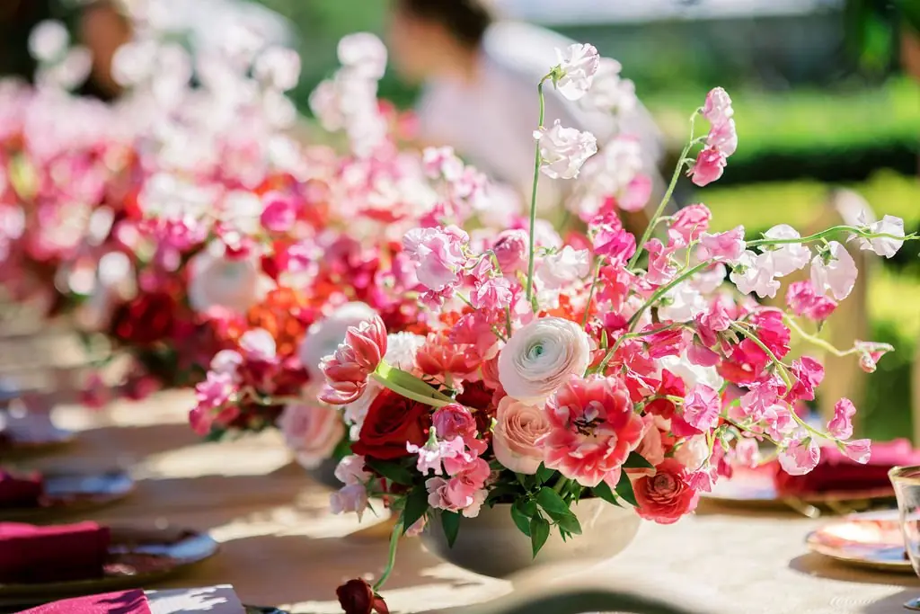 Low bowl of pink and red florals on the brunch tablescape