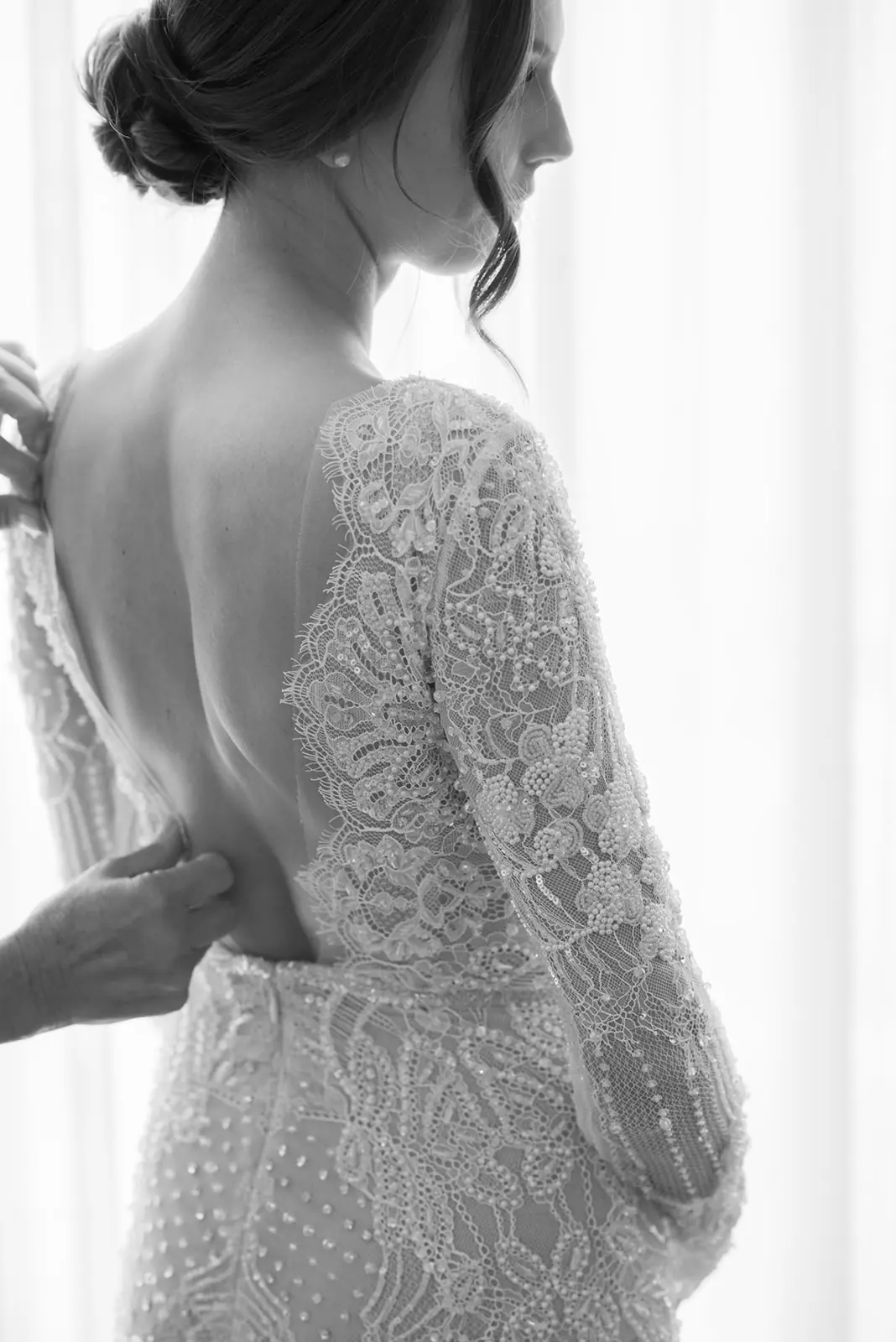 Black-and-white detail of a bride's lace gown and low chignon from behind, styled for a Michigan Avenue Events wedding