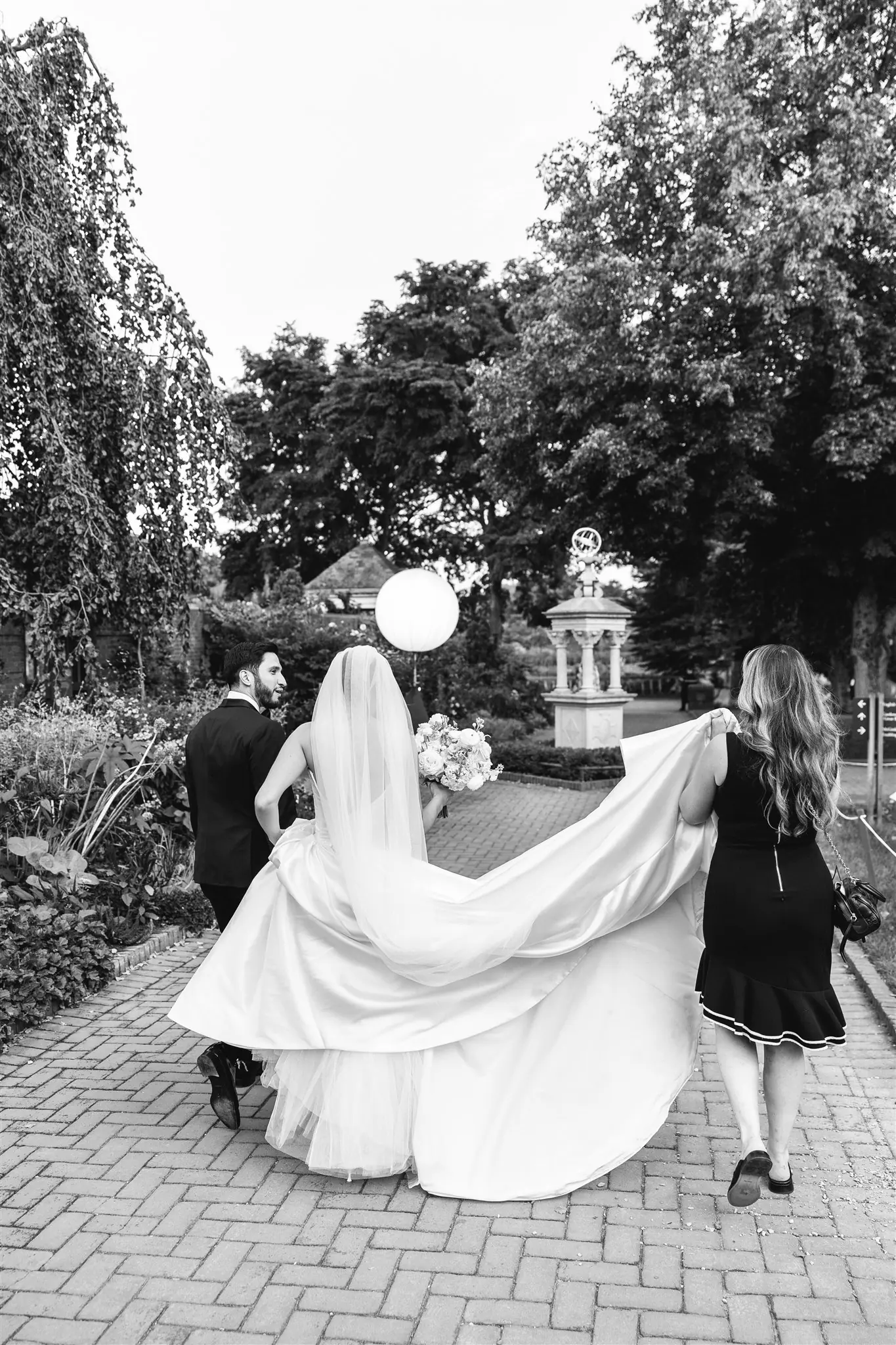 Black-and-white portrait of a couple dancing beneath garden trees at a wedding planned by Michigan Avenue Events