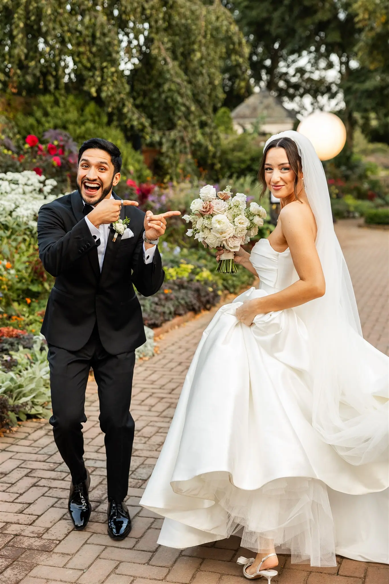 Groom serenading his bride on violin along a garden path at a wedding planned by Michigan Avenue Events
