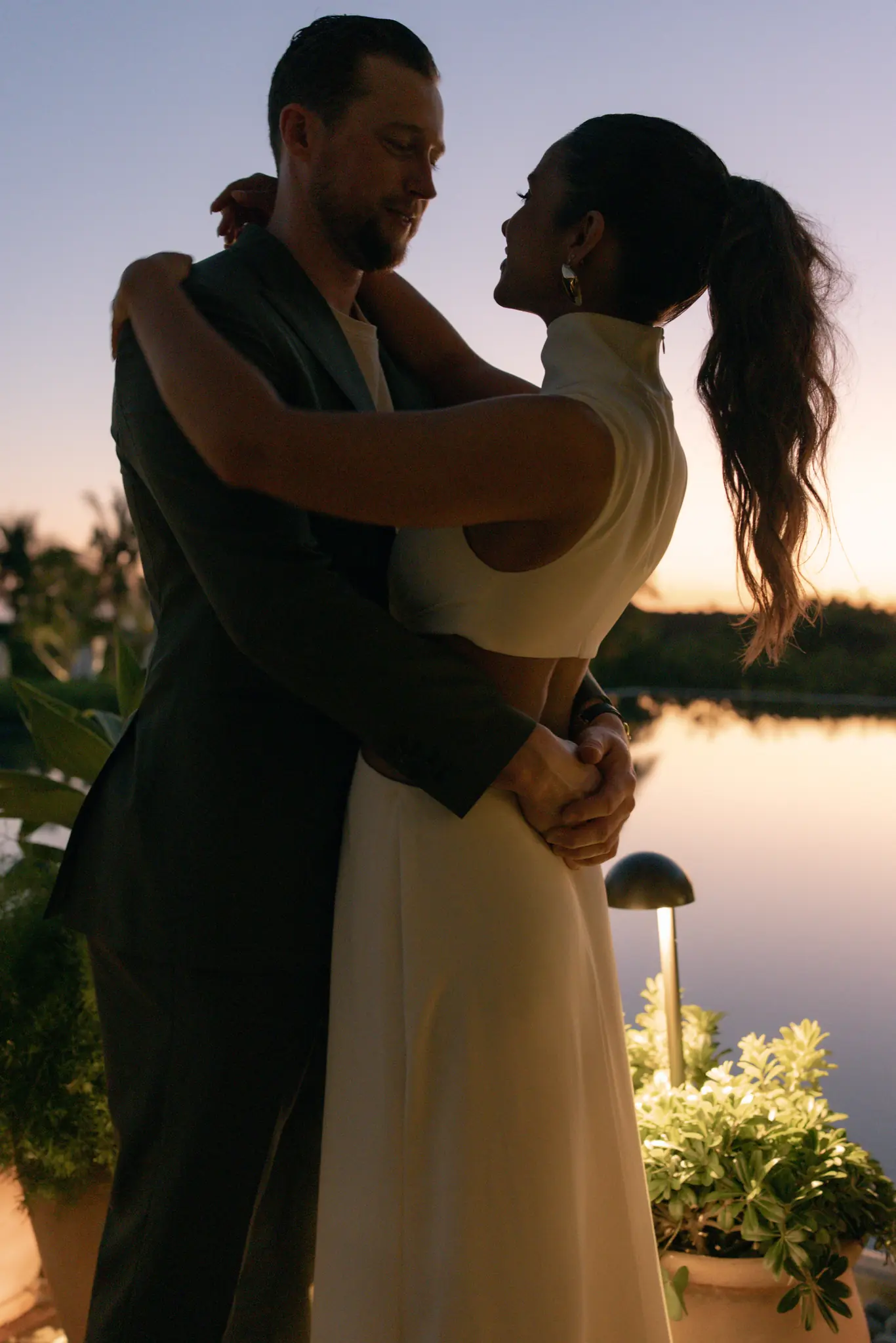 Couple embracing at sunset on a lakeside terrace at a wedding planned by Michigan Avenue Events