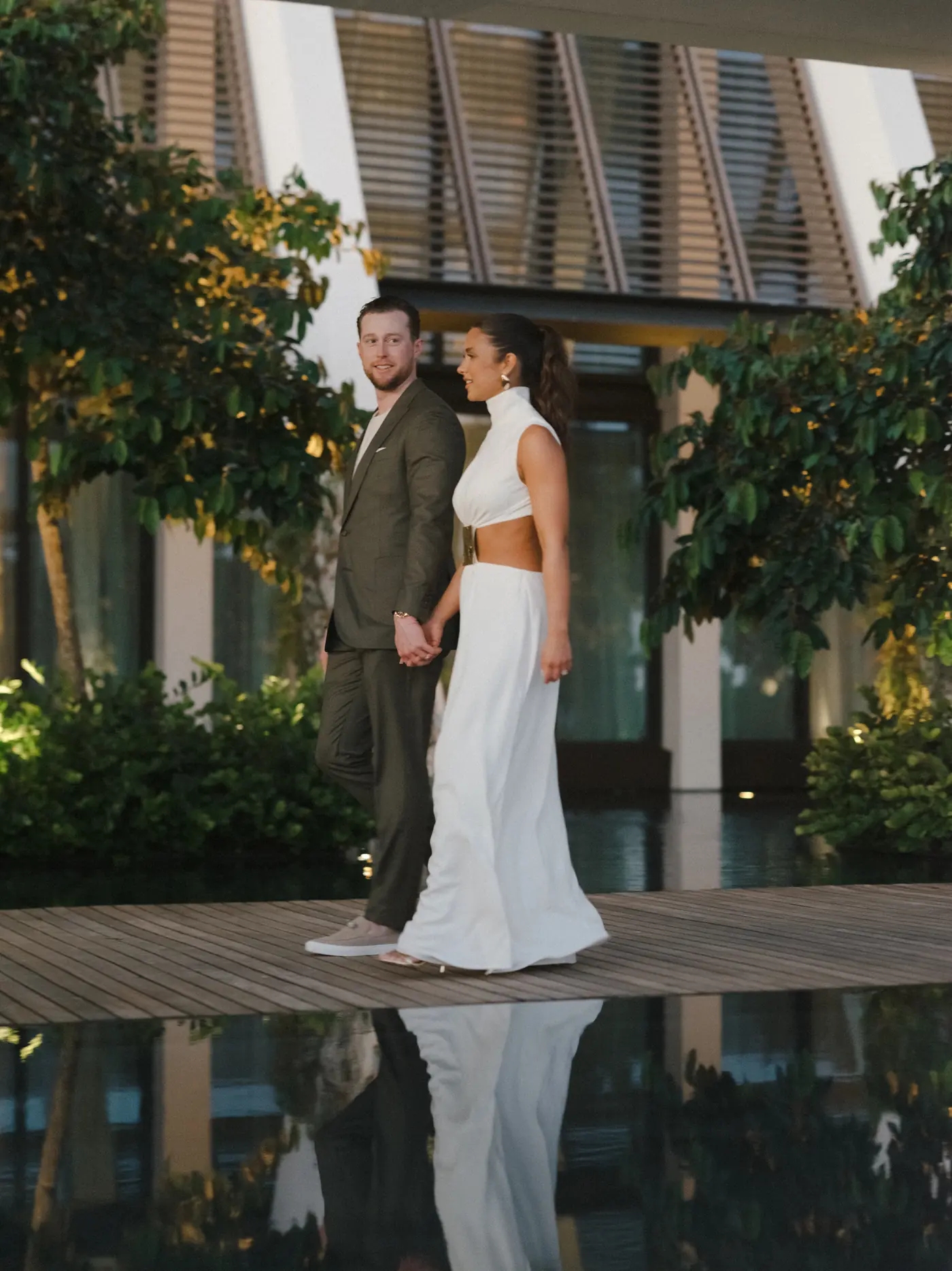 Couple standing poolside in evening wear at a destination wedding planned by Michigan Avenue Events