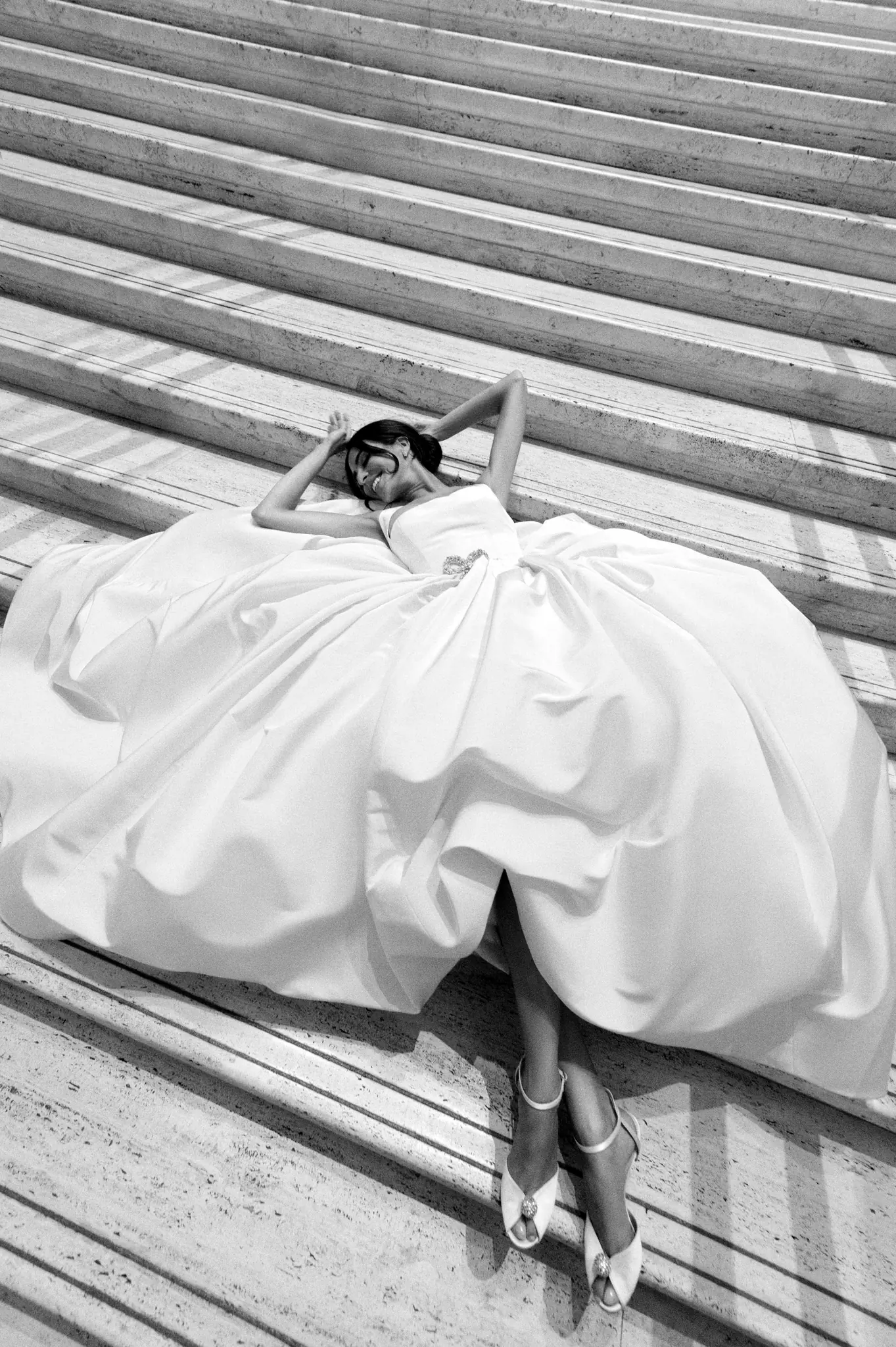 Black-and-white portrait of a bride reclining on a grand staircase at a Chicago wedding planned by Michigan Avenue Events