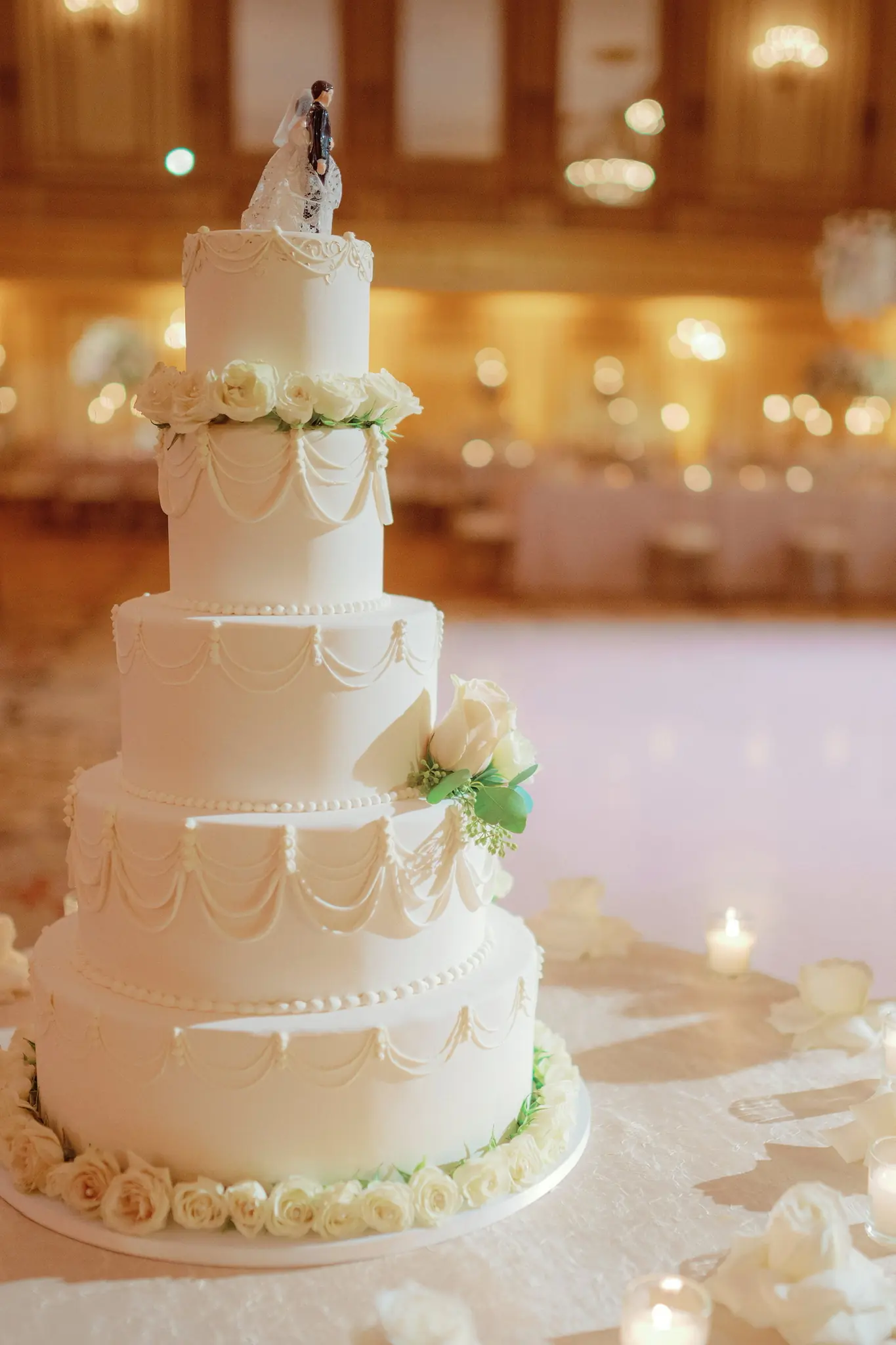 Tiered white wedding cake dressed in fresh blooms inside a Chicago ballroom at a Michigan Avenue Events wedding