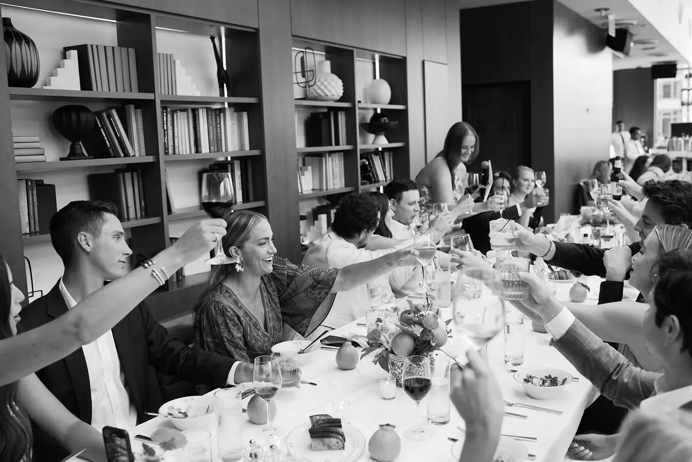 Black-and-white view of a candlelit dinner in a wood-panelled library at a wedding planned by Michigan Avenue Events