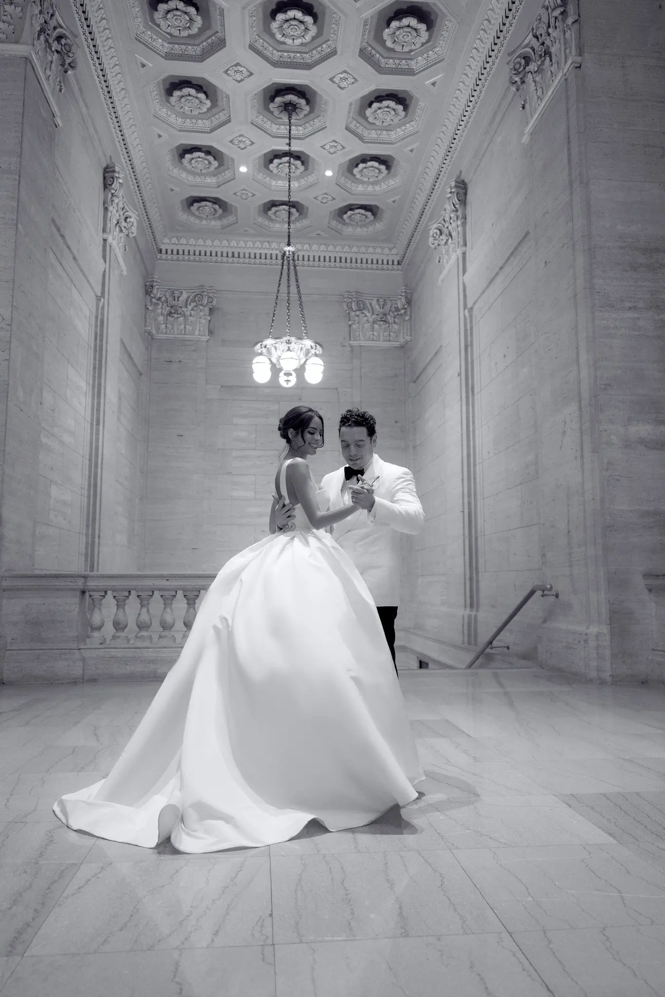 Black-and-white portrait of a couple beneath a Gothic stone archway at a Chicago wedding planned by Michigan Avenue Events