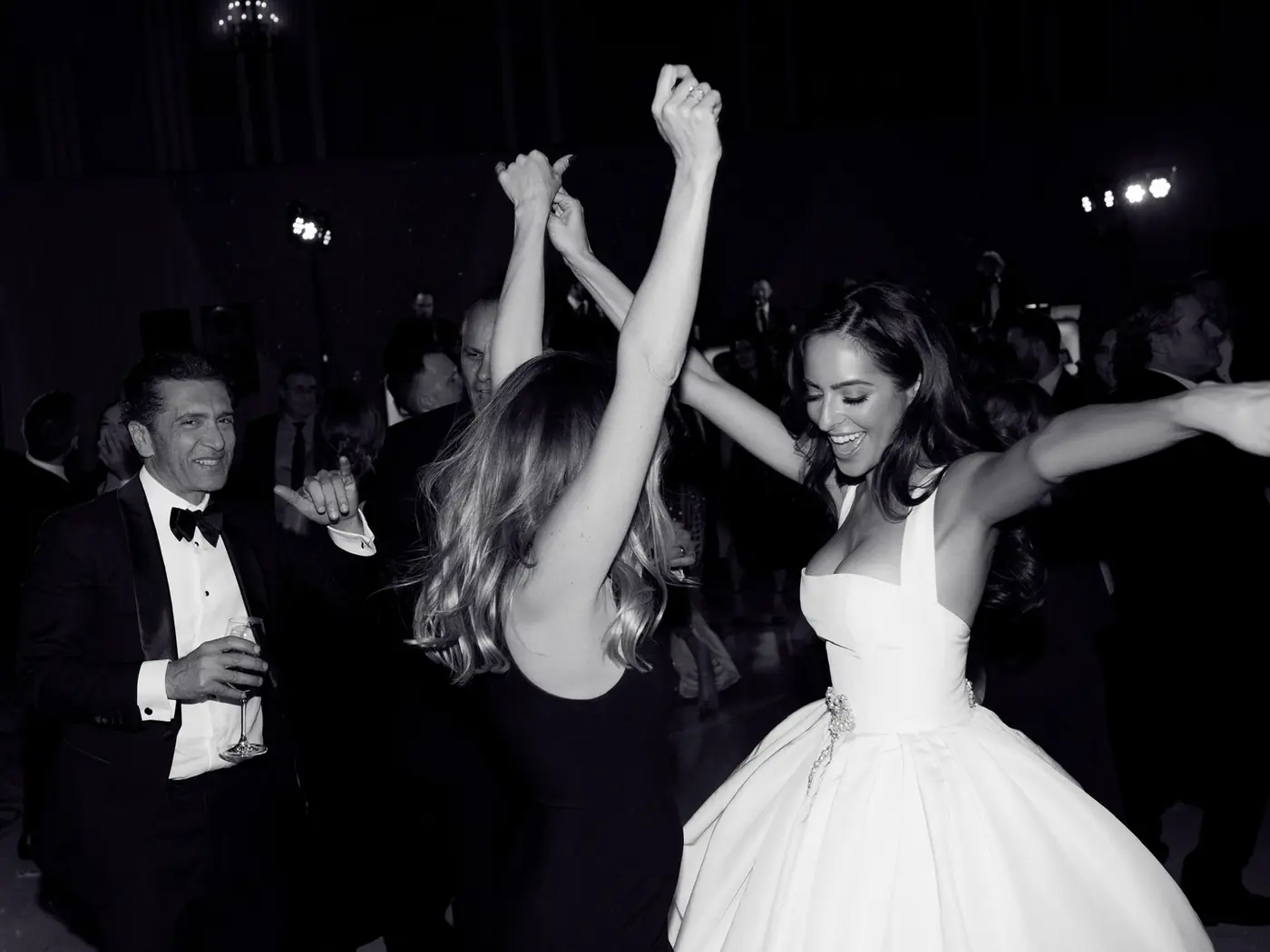 Black-and-white photo of the bride with arms raised on the dance floor at a Michigan Avenue Events wedding