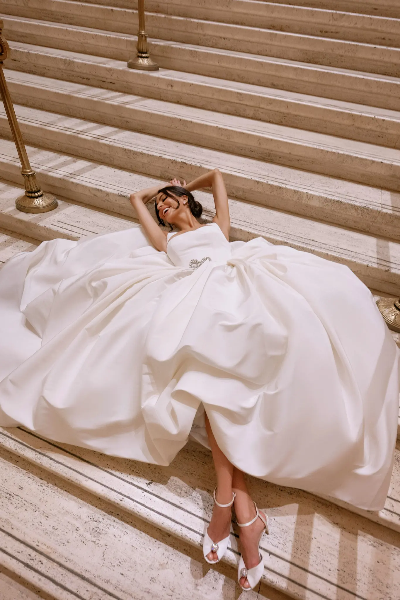 Bride seated on a marble staircase with her gown fanned around her at a Chicago wedding planned by Michigan Avenue Events