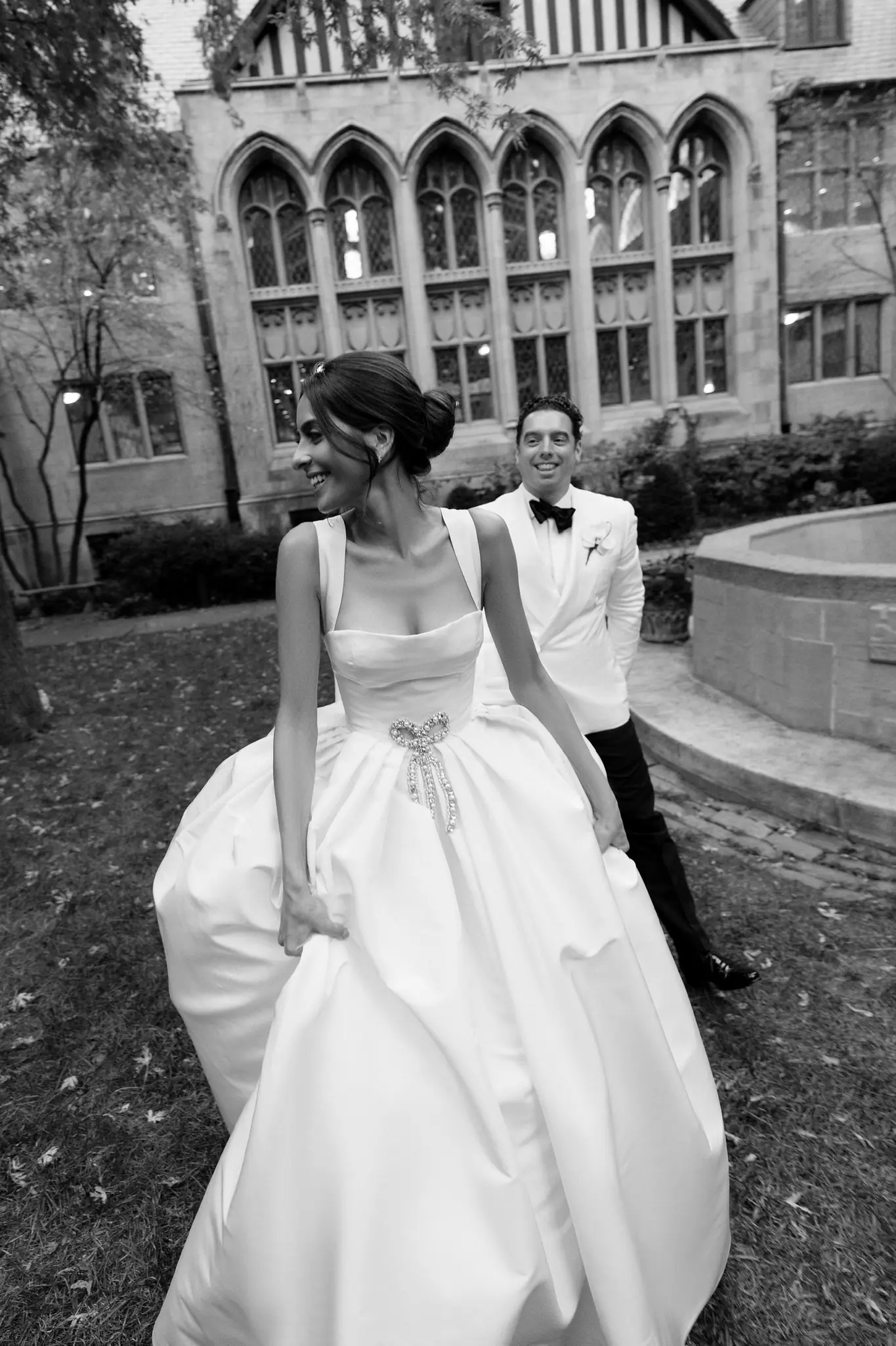 Black-and-white portrait of a couple on a Gothic campus lawn at a Chicago wedding planned by Michigan Avenue Events