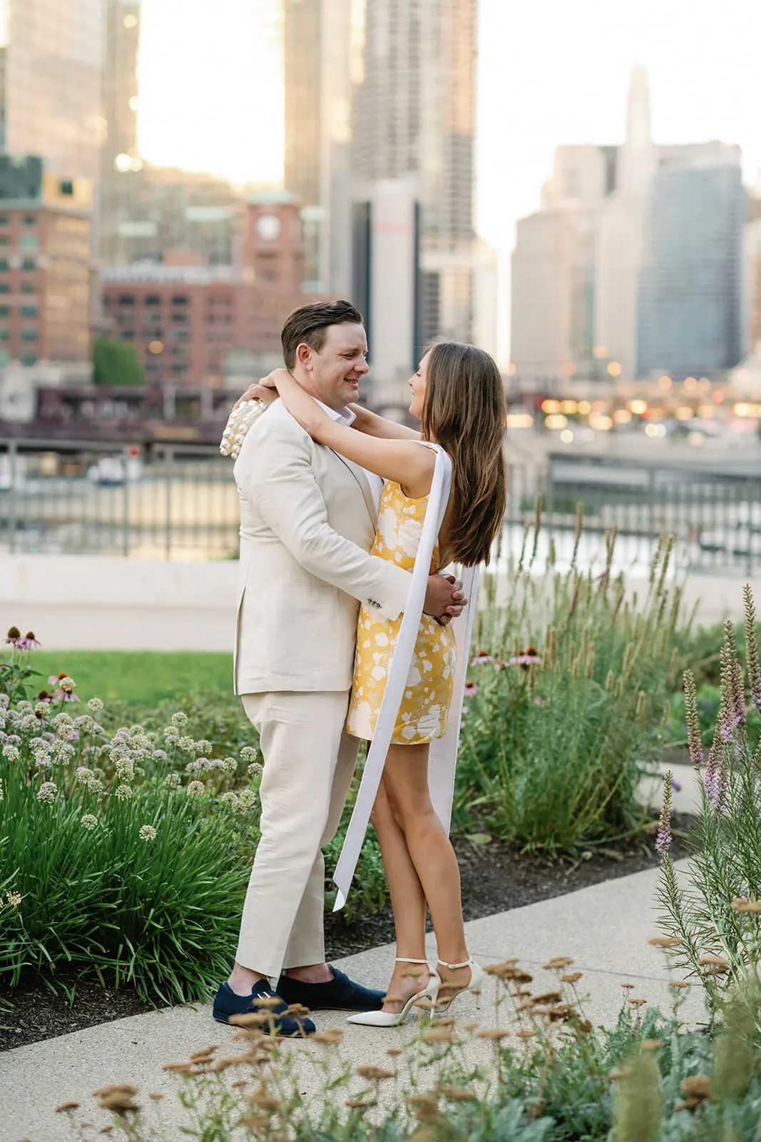 Couple embracing in a rooftop garden with the Chicago skyline behind them at a wedding planned by Michigan Avenue Events