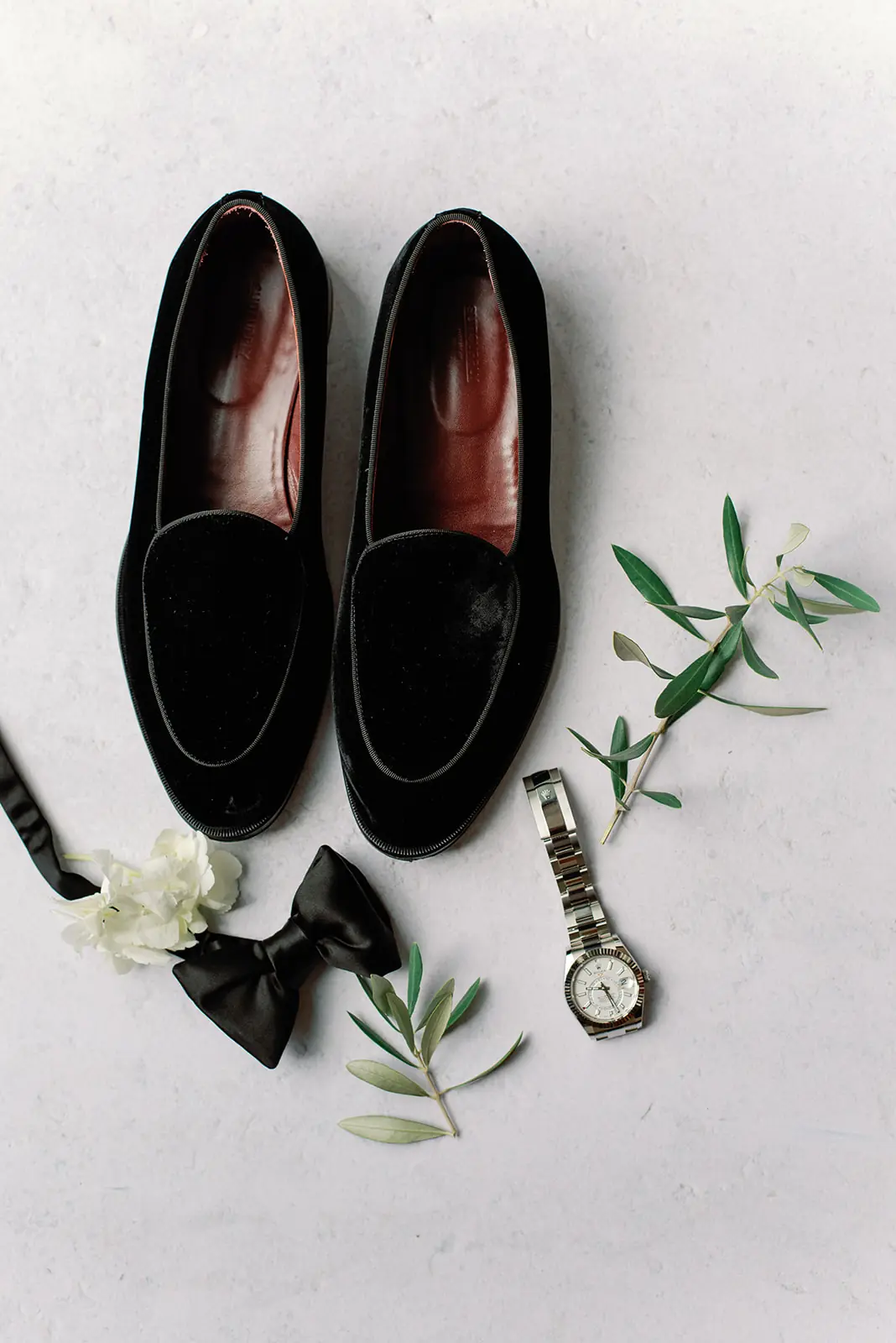 Groom's loafers, cufflinks, and pocket watch styled with olive sprigs at a wedding planned by Michigan Avenue Events