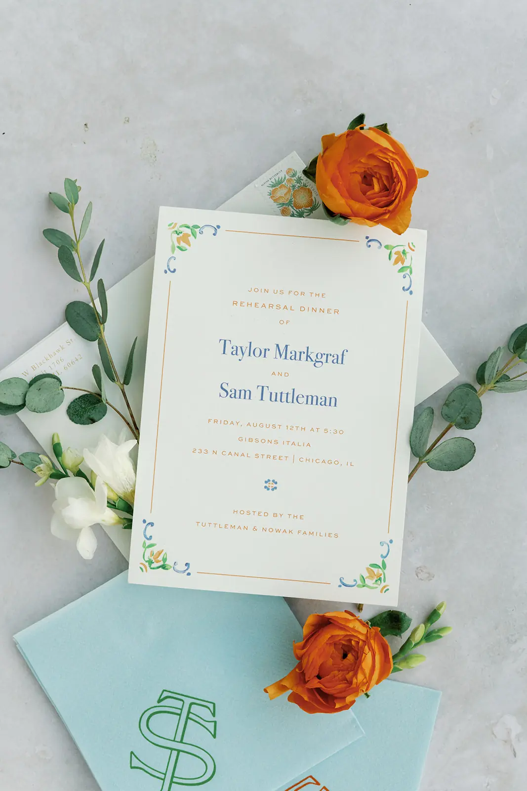 Invitation suite with orange florals and a teal envelope liner at a wedding planned by Michigan Avenue Events