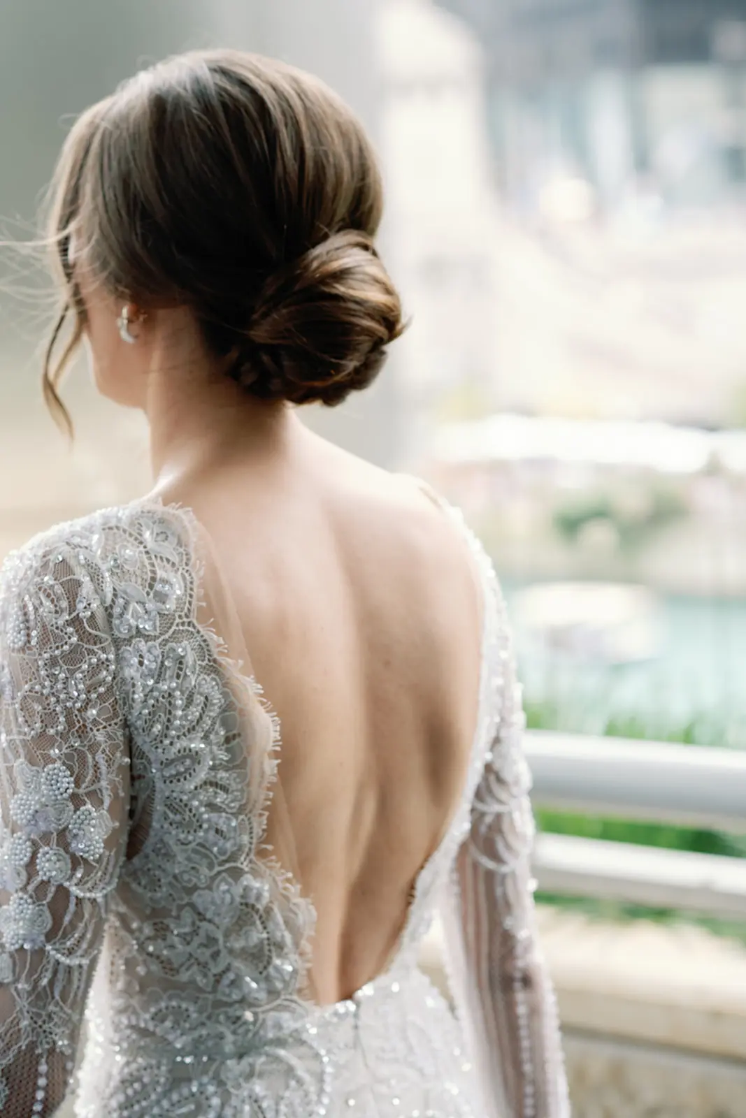 Bride in a backless lace gown photographed from behind in a rooftop garden at a Chicago wedding planned by Michigan Avenue Events