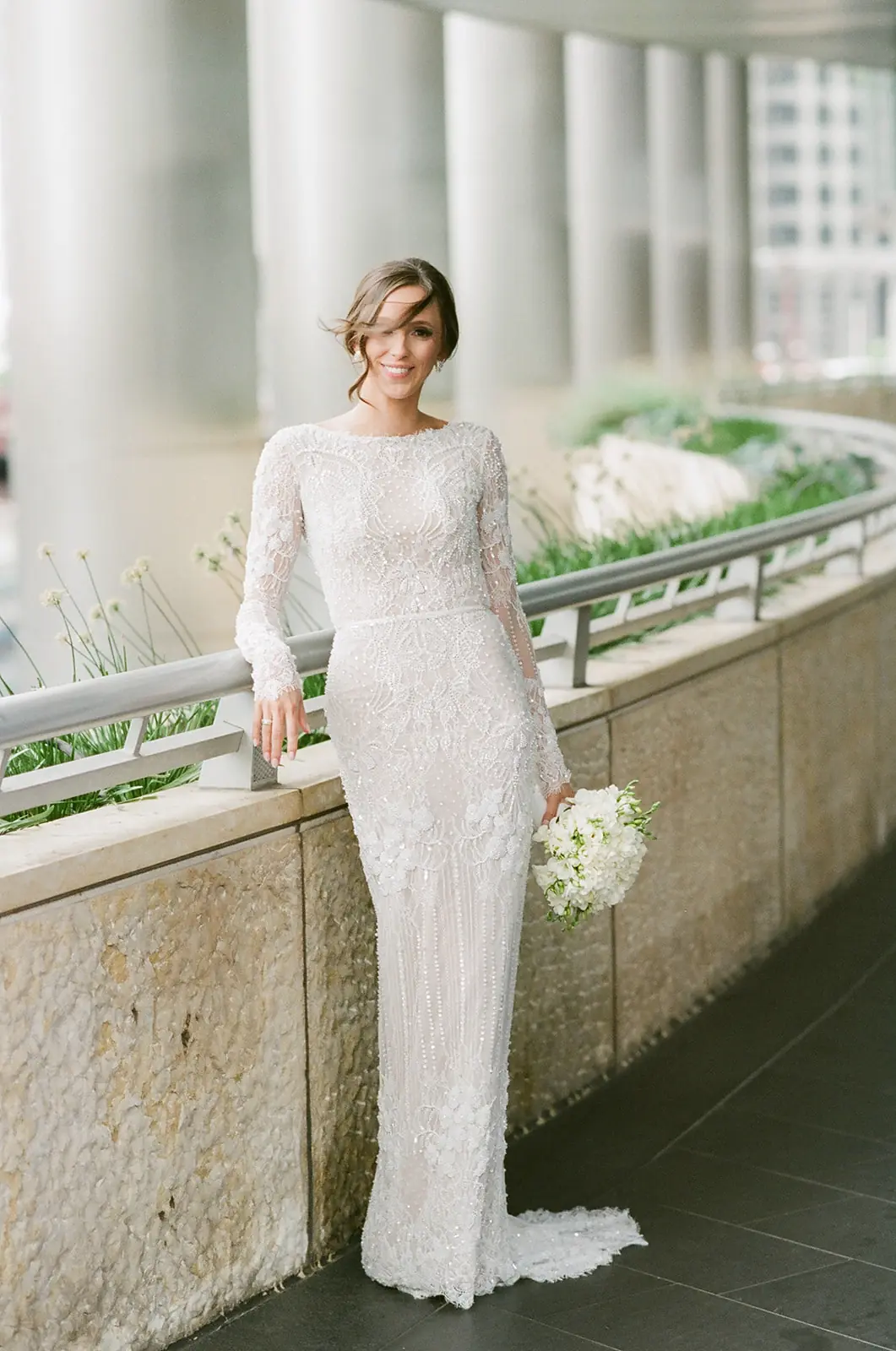 Bride in a long-sleeved lace gown standing by the Chicago River at a wedding planned by Michigan Avenue Events