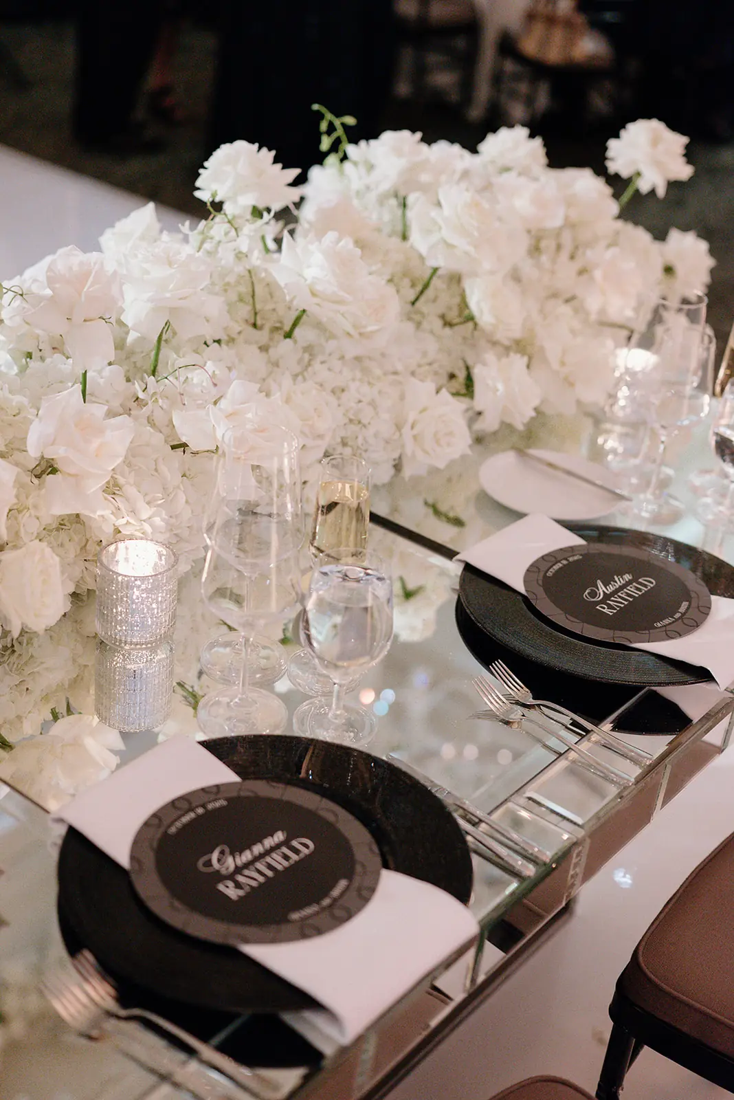 Black-and-white detail of white roses and menu cards on a reception table at a Michigan Avenue Events wedding