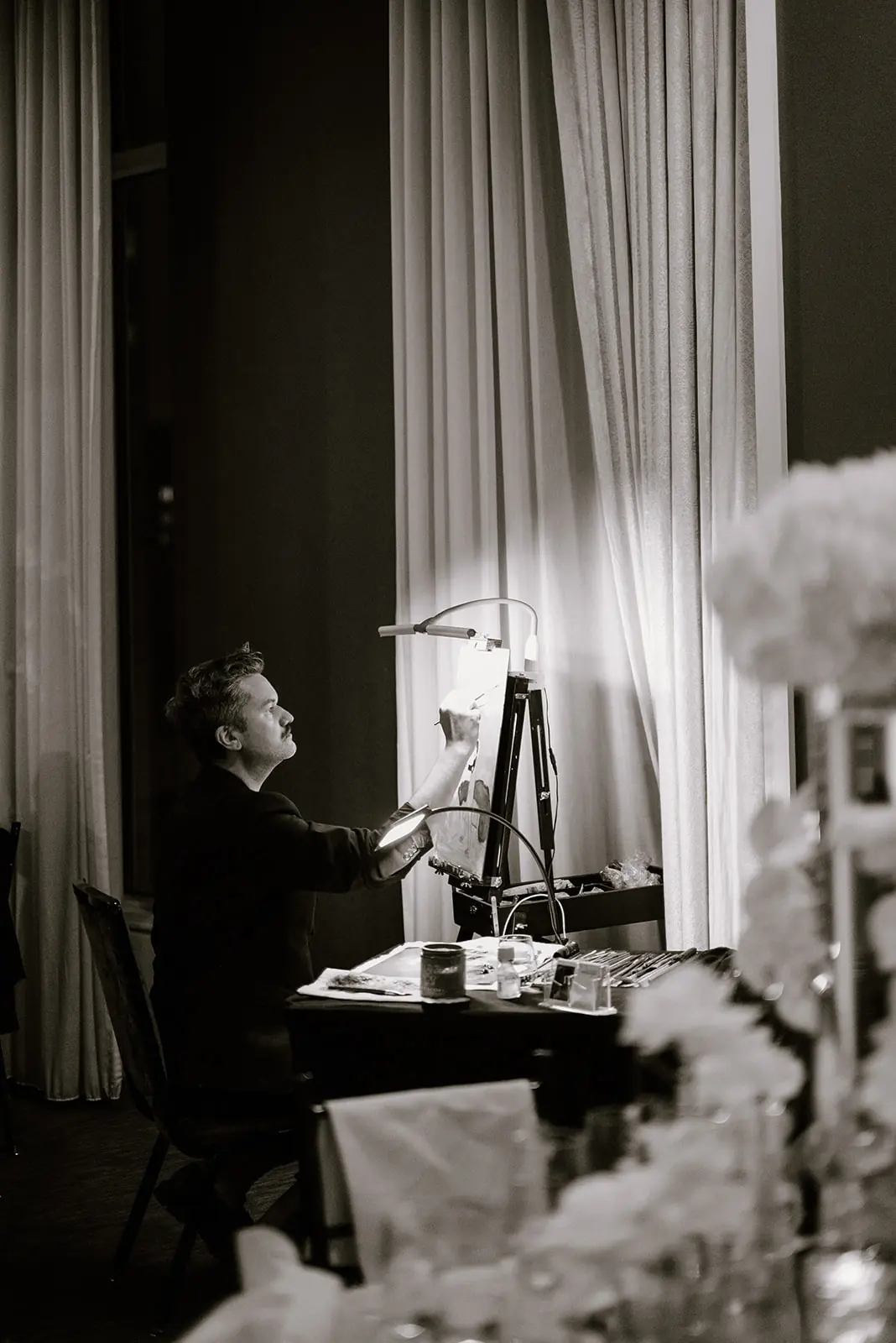 Black-and-white photo of a bride at a mirror in soft window light before a Michigan Avenue Events wedding