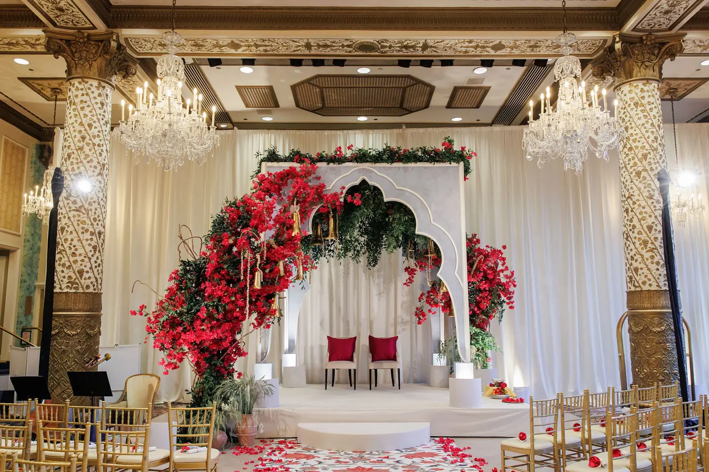 Ballroom mandap dressed in red florals with a petal-strewn aisle at a wedding planned by Michigan Avenue Events