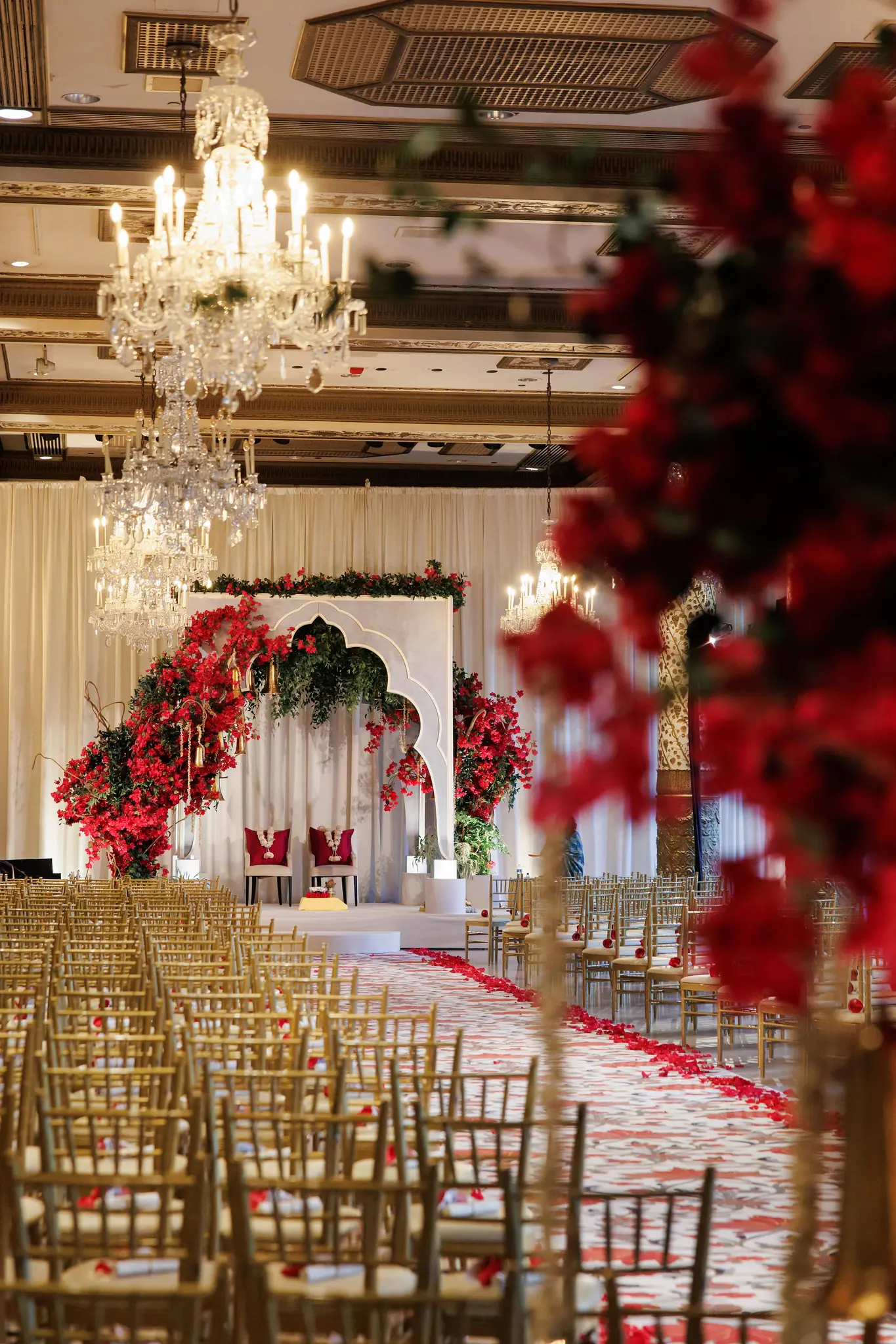 Side view of a red floral mandap and gold chairs in a Chicago ballroom at a wedding planned by Michigan Avenue Events