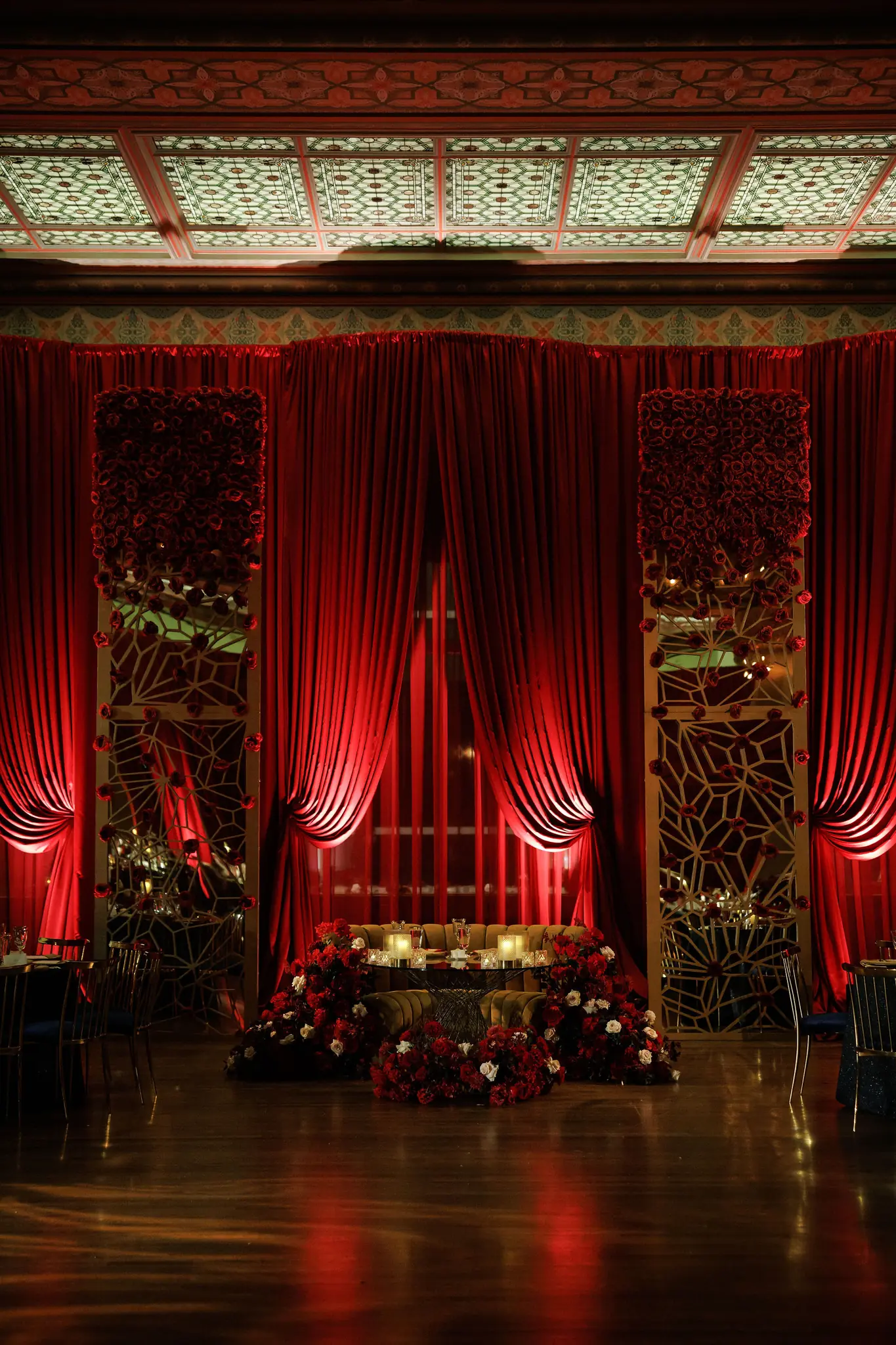 Red-draped stage with a jewelled backdrop in a ballroom at a celebration planned by Michigan Avenue Events