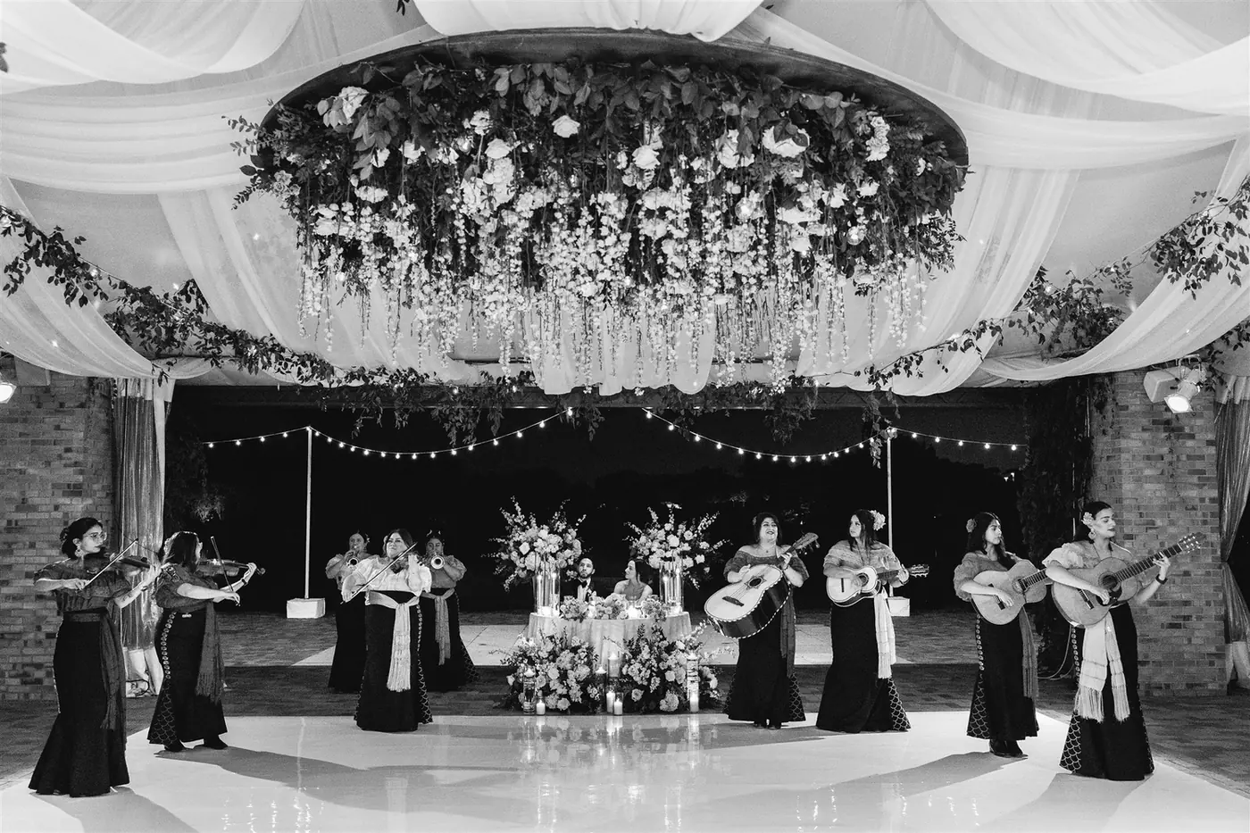 Black-and-white photo of a string ensemble performing beneath a floral ceiling at a Michigan Avenue Events celebration