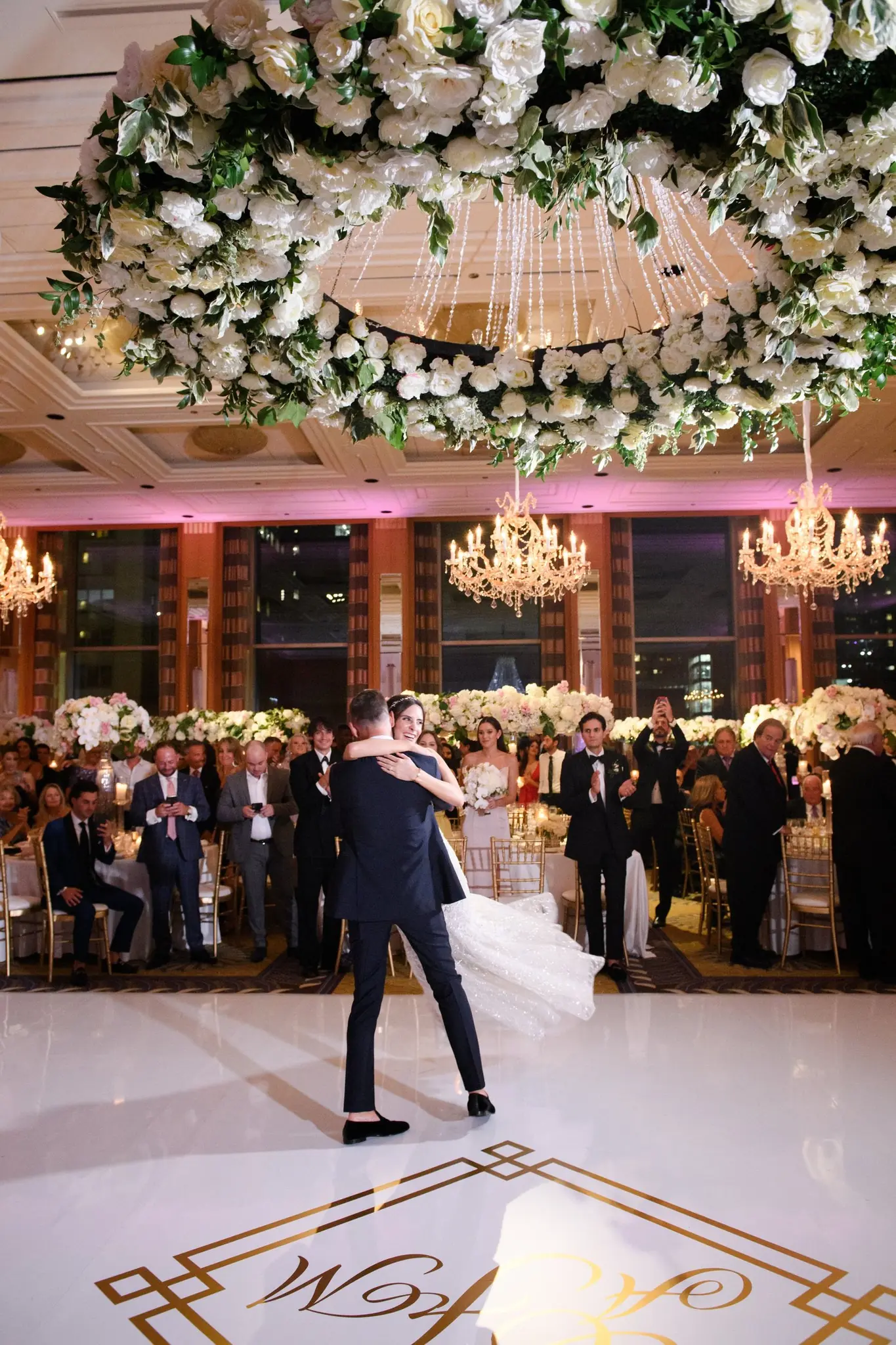 Alexis and Michael's first dance beneath a floral chandelier