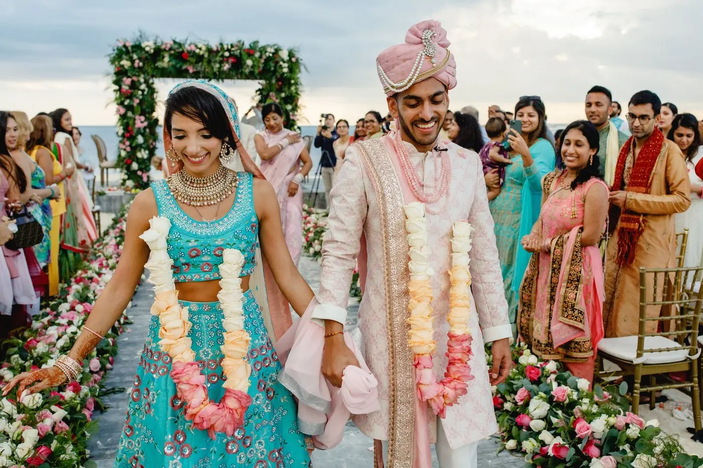 Lara Sofia and Atul walking the floral aisle after their beach mandap ceremony at NIZUC