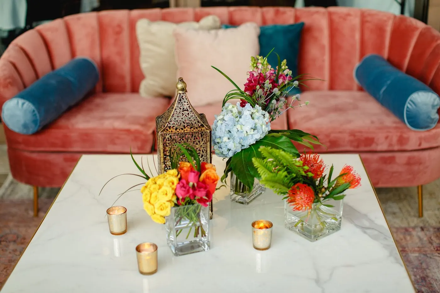 Pink velvet lounge with marble table and colorful florals at Lara Sofia and Atul's celebration