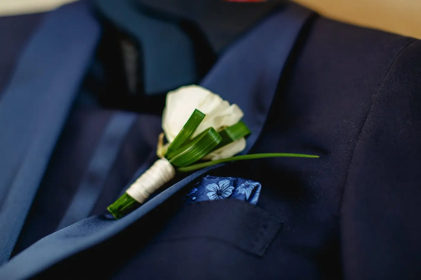 Atul's white boutonnière and blue pocket square on his navy jacket