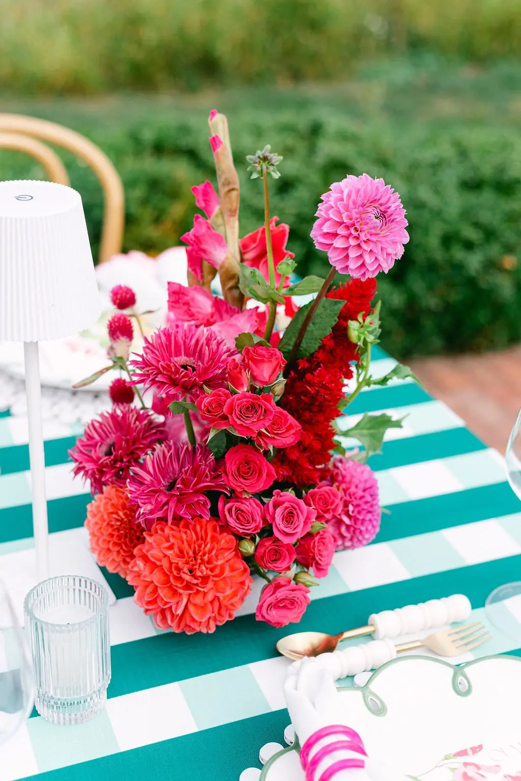 Vibrant floral centerpiece on teal striped linens at Lisa and Matt's reception